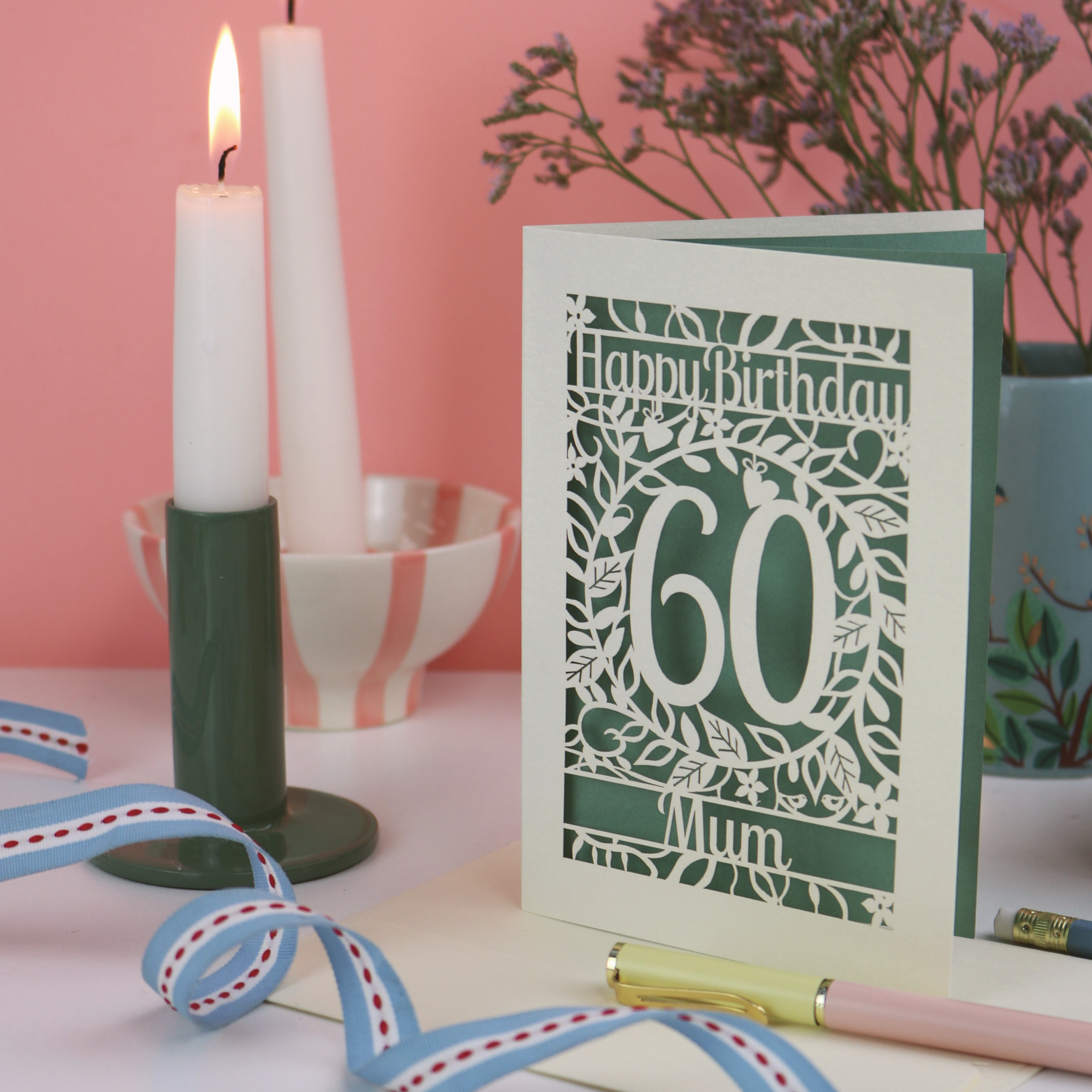 Laser cut 60th Birthday card for Mum with number 60 on a table with candles and flowers.