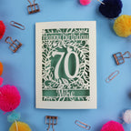 A laser cut 70th birthday card with 'Happy Birthday' and personalised with the recipient's name. The number 70 is in the centre, surrounded by leaf and floral cut out designs. 