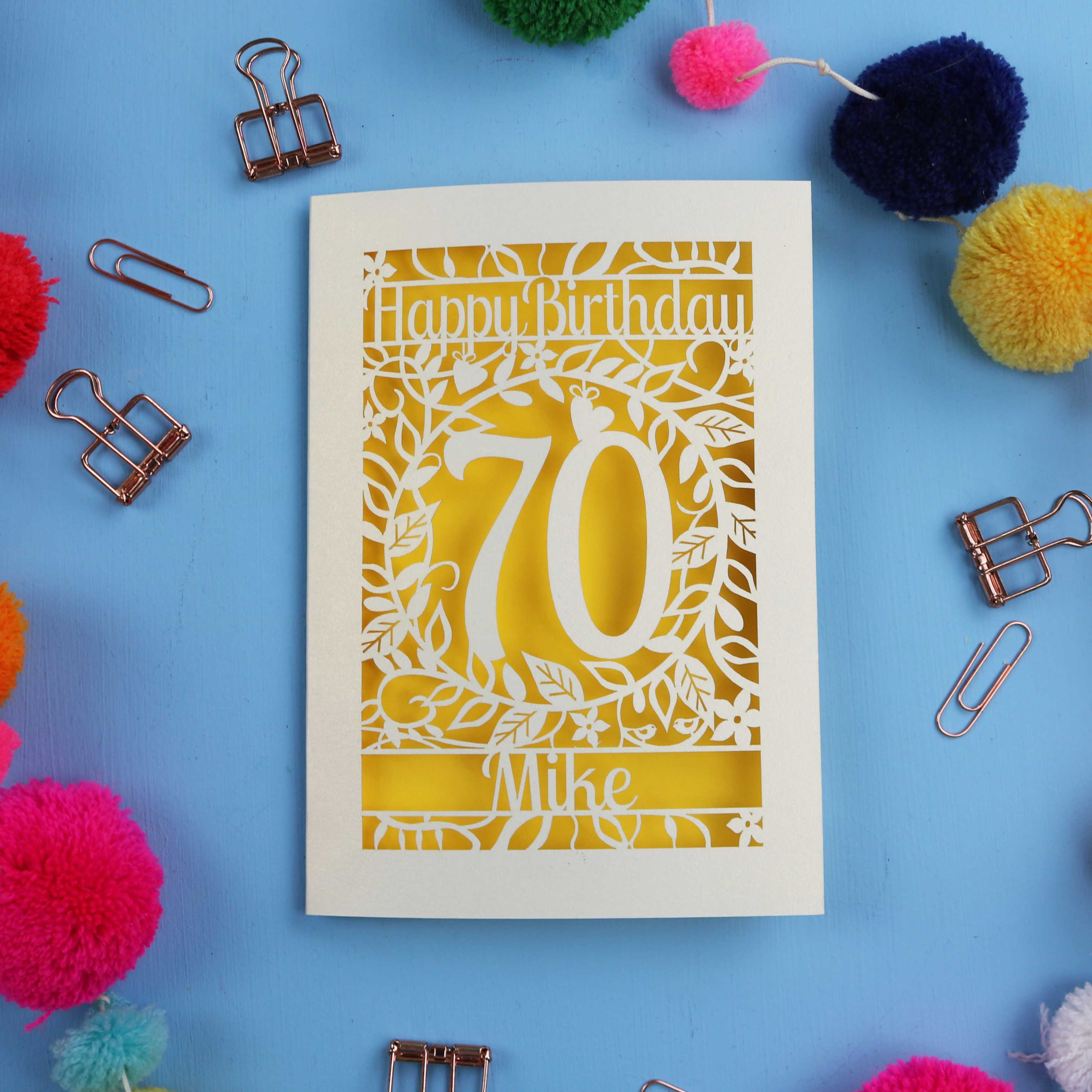 A personalised 70th birthday card with 'Happy Birthday' and personalised with the recipient's name. The number 70 is in the centre, surrounded by leaf and floral cut out designs. 