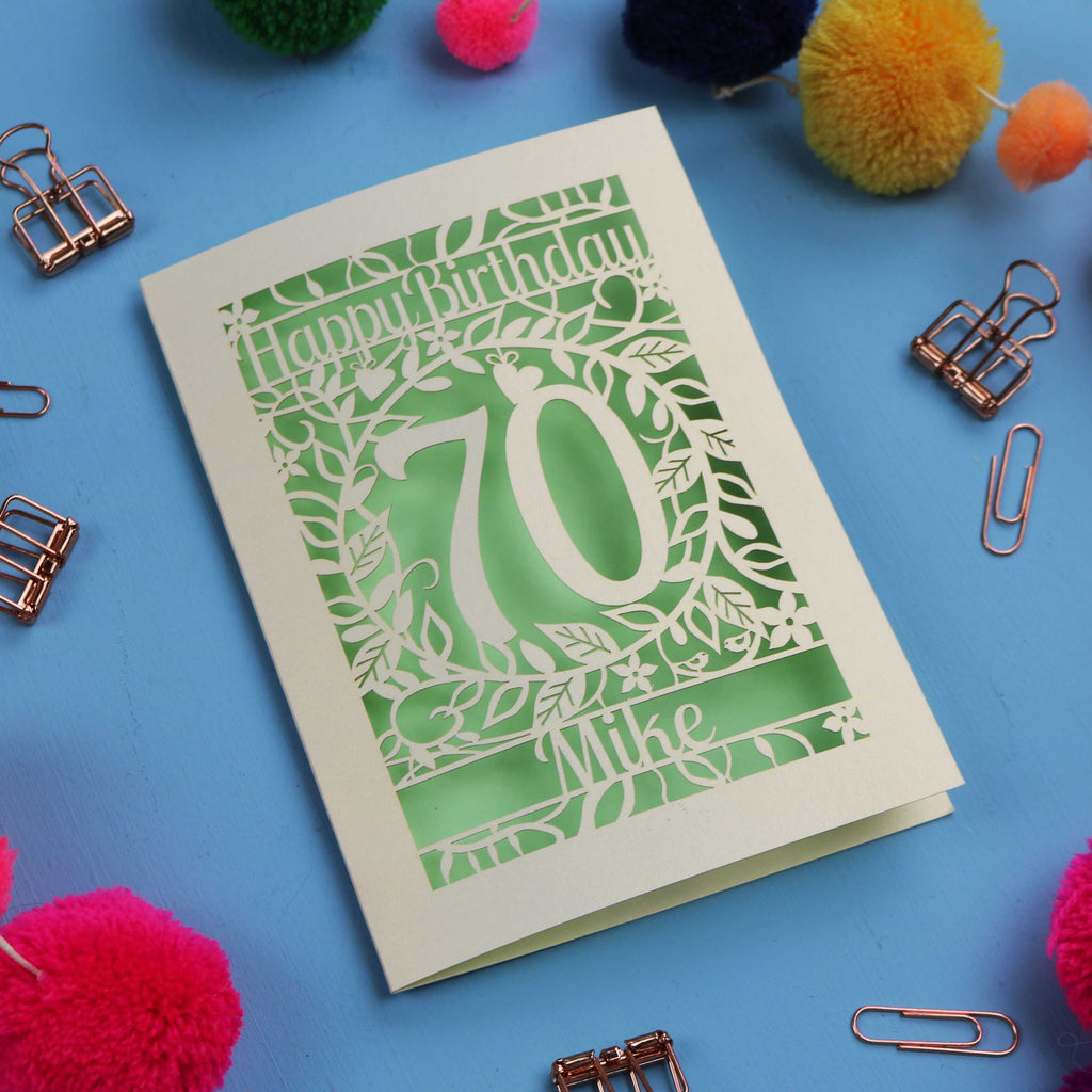 A luxury 70th birthday card with 'Happy Birthday' and personalised with the recipient's name. The number 70 is in the centre, surrounded by leaf and floral cut out designs. 