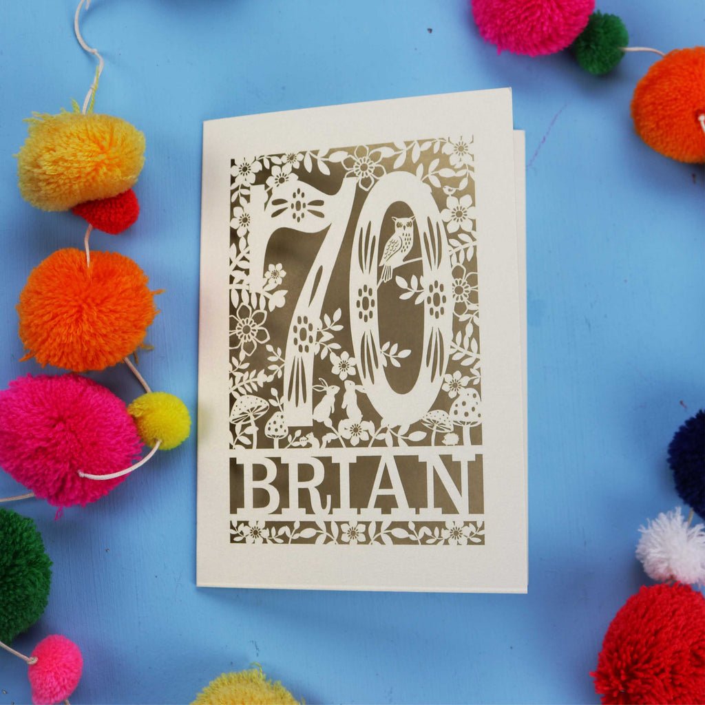 A personalised  luxury laser cut 70th birthday card featuring the number 70 and woodland cut out details. 