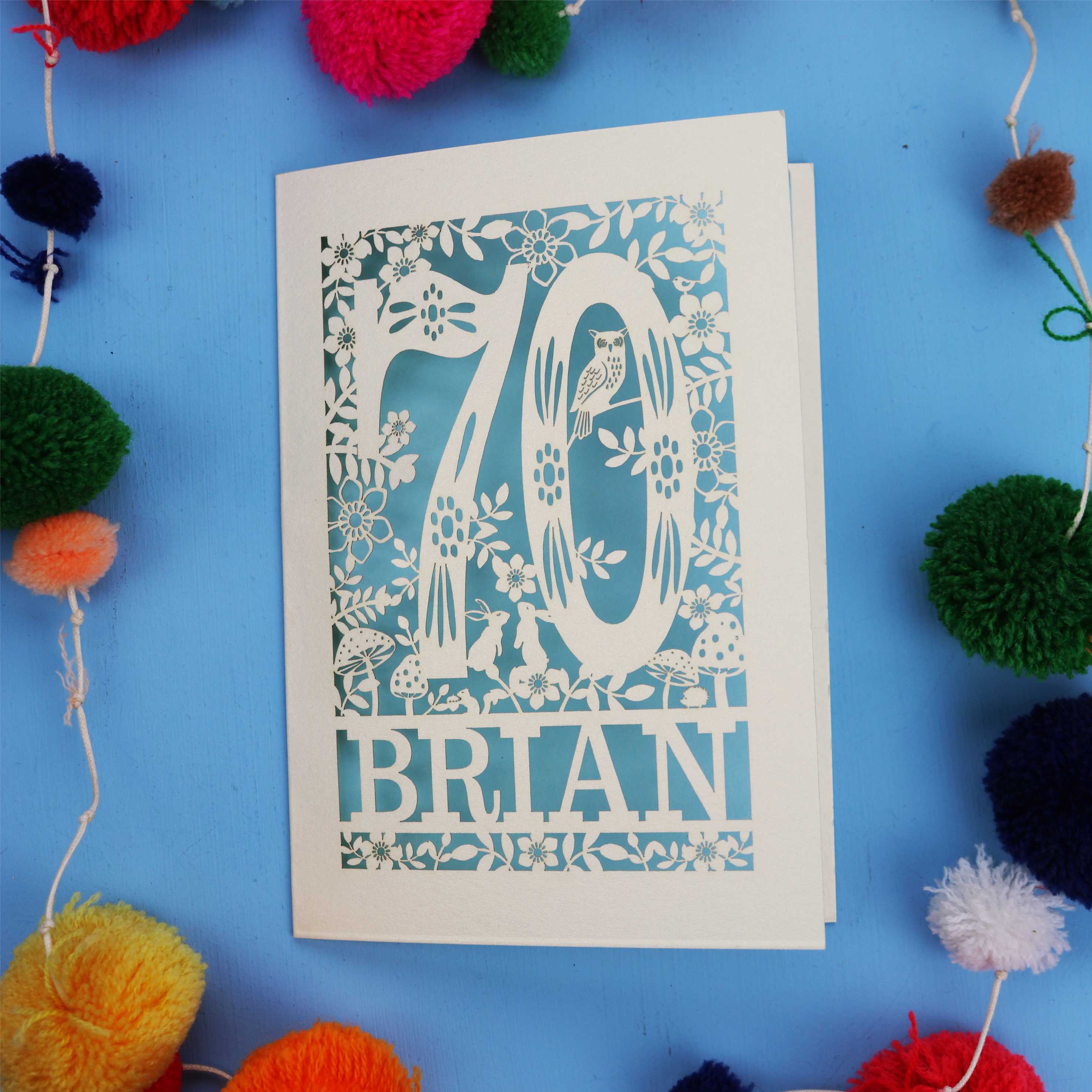 A personalised paper cut 70th birthday card featuring the number 70 and woodland cut out details. 