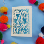 A personalised laser cut 70th birthday card featuring the number 70 and woodland cut out details. 