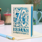 Decorative 70th birthday card with floral  woodland design and '70' 'Brian' text on a table.