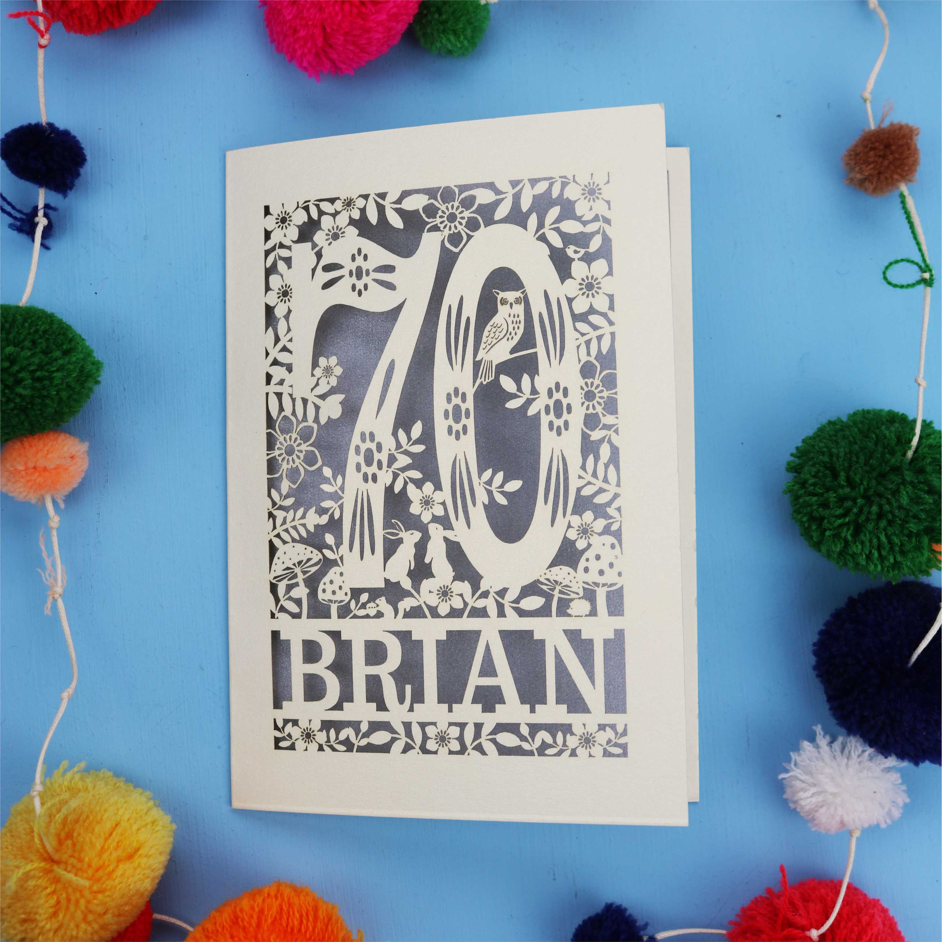 A personalised laser cut 70th birthday card featuring the number 70 and woodland cut out details. 