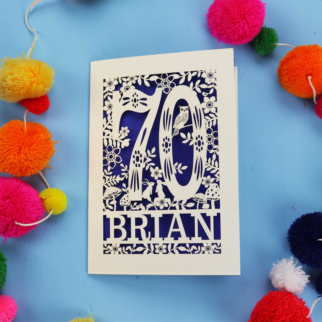 A personalised laser cut 70th birthday card featuring the number 70 and woodland cut out details. 