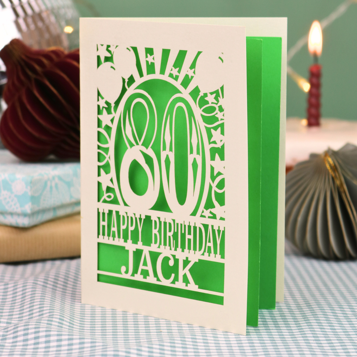 A personalised birthday card for 80th birthday, with decorative number '80' and text, 'Happy Birthday Jack', and a cut out border with stars and balloons. 