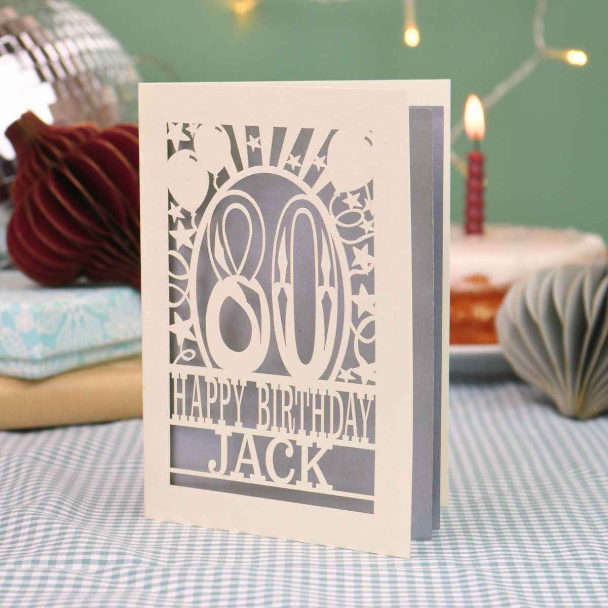 A personalised birthday card for 80th birthday, with decorative number '80' and text, 'Happy Birthday Jack', and a cut out border with stars and balloons. 