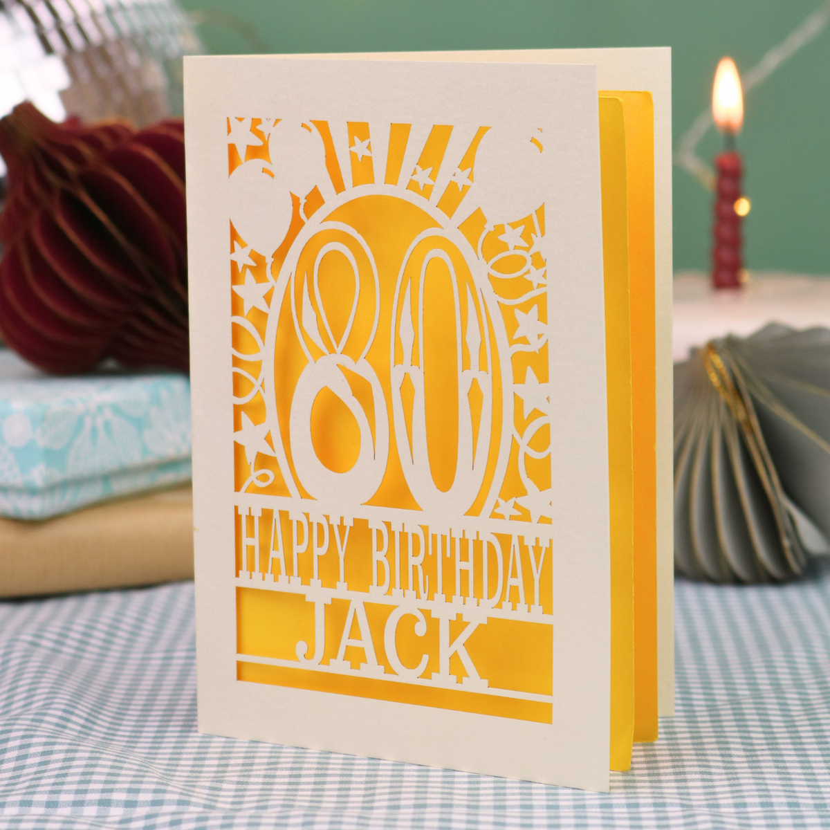 A personalised birthday card for 80th birthday, with decorative number '80' and text, 'Happy Birthday Jack', and a cut out border with stars and balloons. 