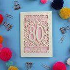 Special 80th Birthday card with 'Happy Birthday 80 Karen' on a blue background with colourful pom-poms and paper clips.