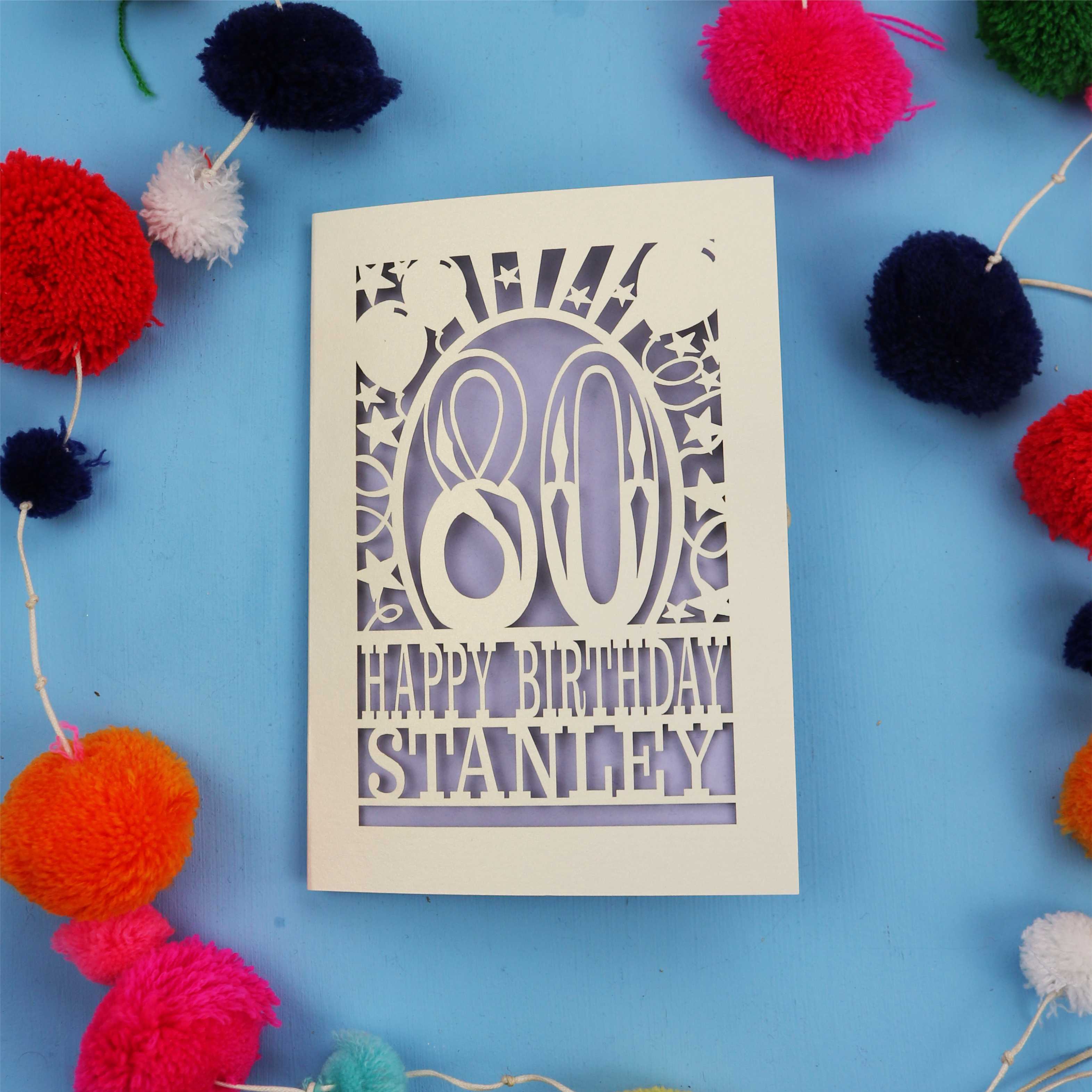 80th Birthday card with 'Happy Birthday Stanley' on a blue background with colourful pom-poms.