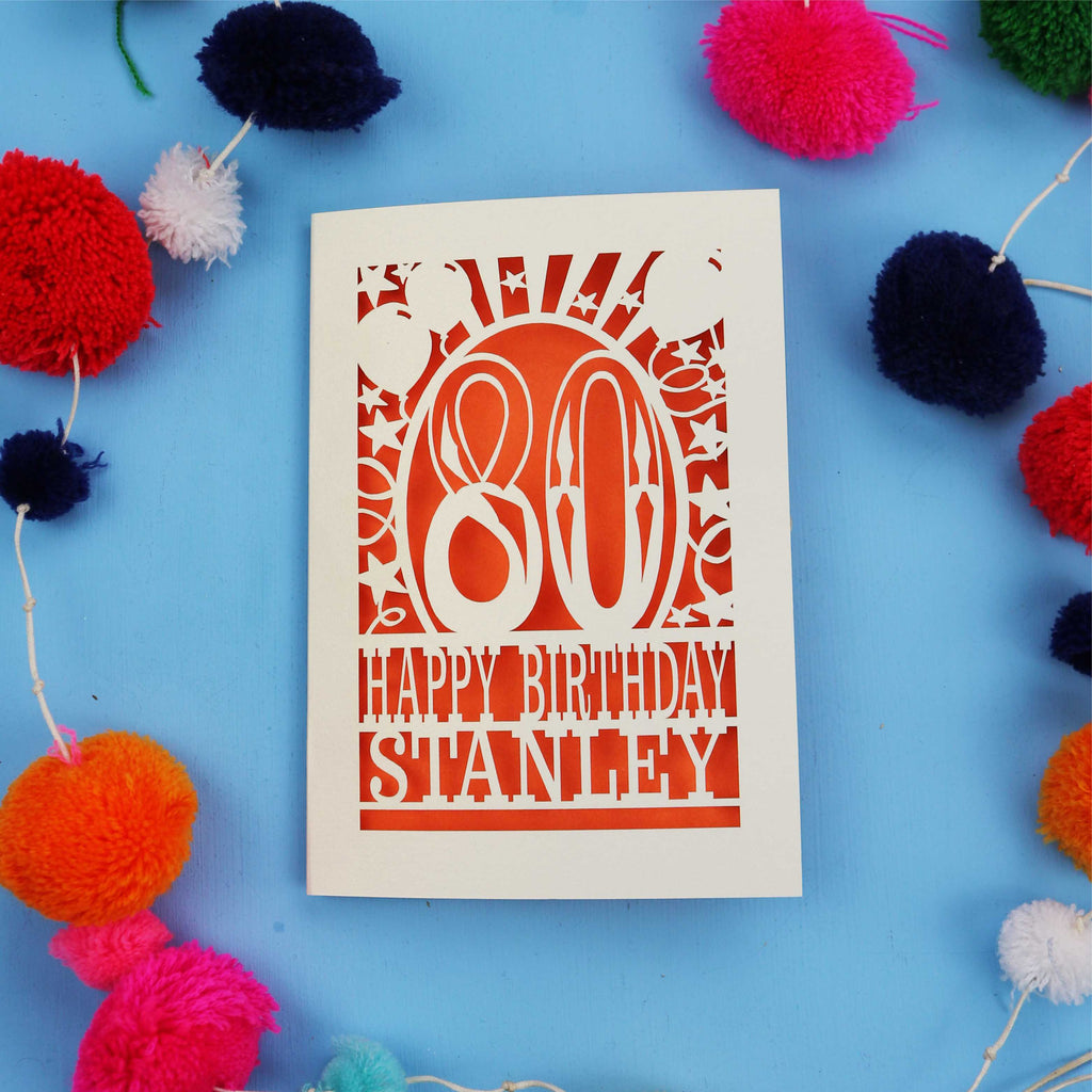 80th Birthday card with 'Happy Birthday Stanley' on a blue background with colourful pom-poms.
