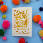 Laser cut 80th Birthday Card with '80' cut out cupcake design on a blue background with colourful pom-poms.