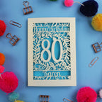 Cut out 80th Birthday card with 'Happy Birthday 80 Karen' on a blue background with decorative items.