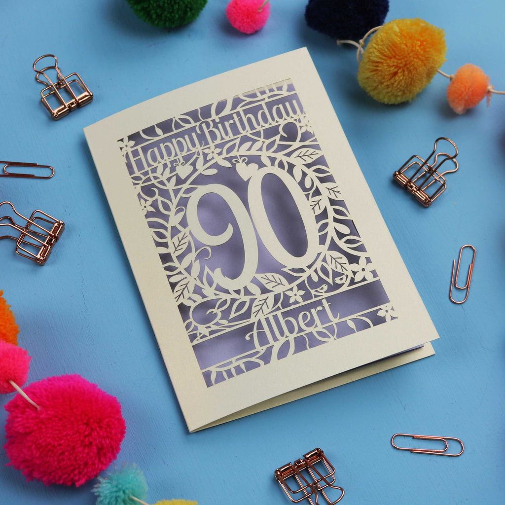 Paper cut out Birthday card with 'Happy Birthday 90 Albert' on a blue background with colourful pom-poms and paper clips.