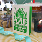 A laser cut 90th birthday card with balloons and stars around a decorative number '90', with personalised text 'Happy Birthday Jean'