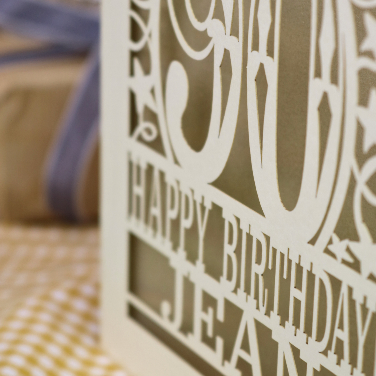 A laser cut 90th birthday card with balloons and stars around a decorative number '90', with personalised text 'Happy Birthday Jean'