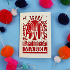 Happy Birthday Mabel - A personalised 90th birthday card with colourful pom-poms on a blue background