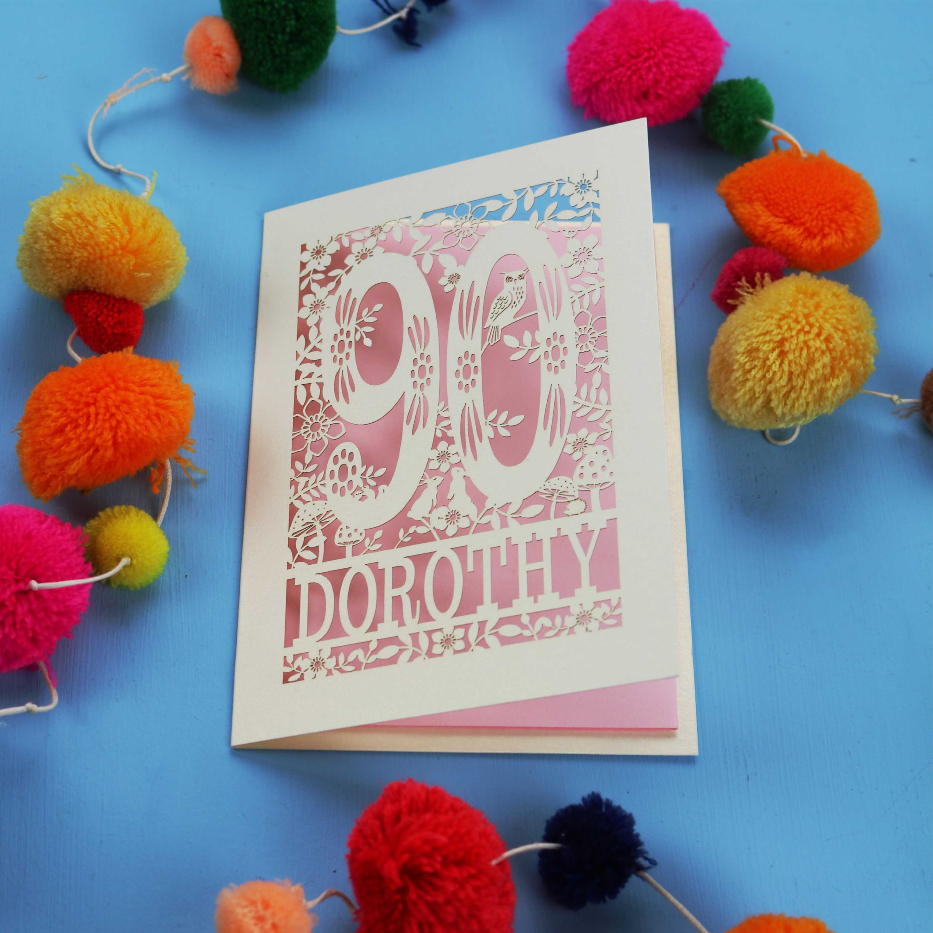90th Birthday Card with '90 Dorothy' design on a blue background with colourful pom-poms.