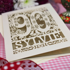 A cut out 90th birthday card with laser-cut woodland details, the number 90, flowers, and an owl over a gold leaf background, personalized with the name 'SYLVIE' at the bottom. 