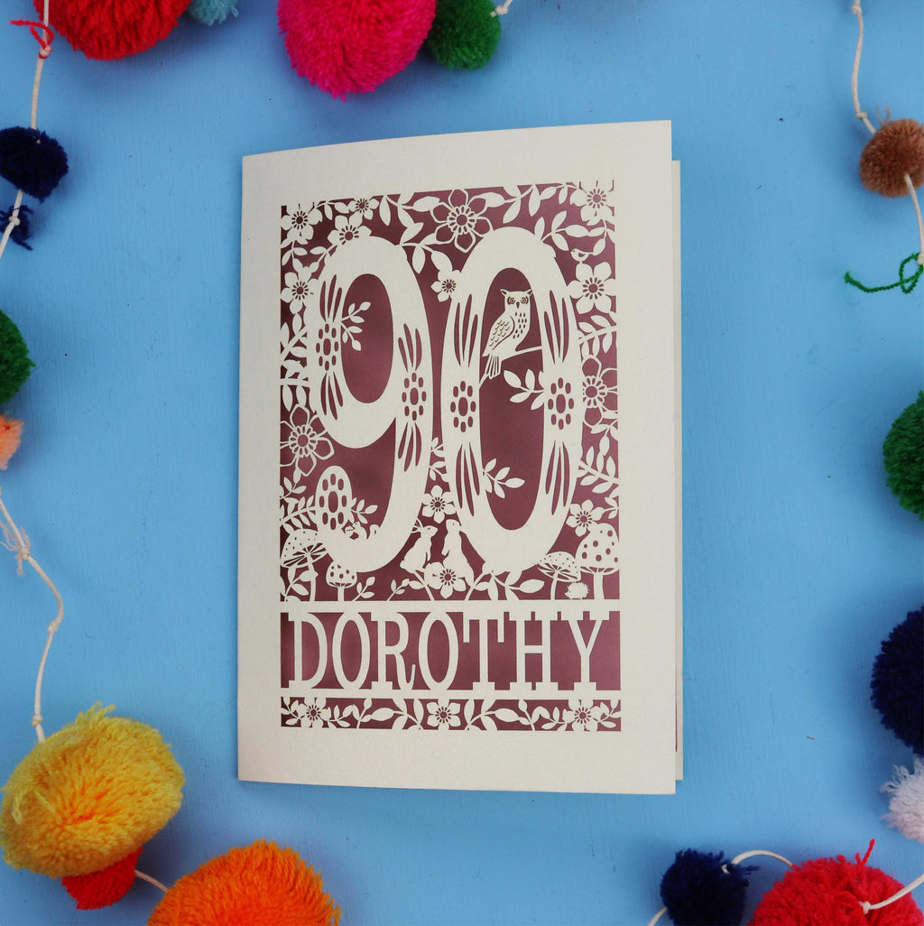 90th Birthday Card with '90 Dorothy' design on a blue background with colourful pom-poms.
