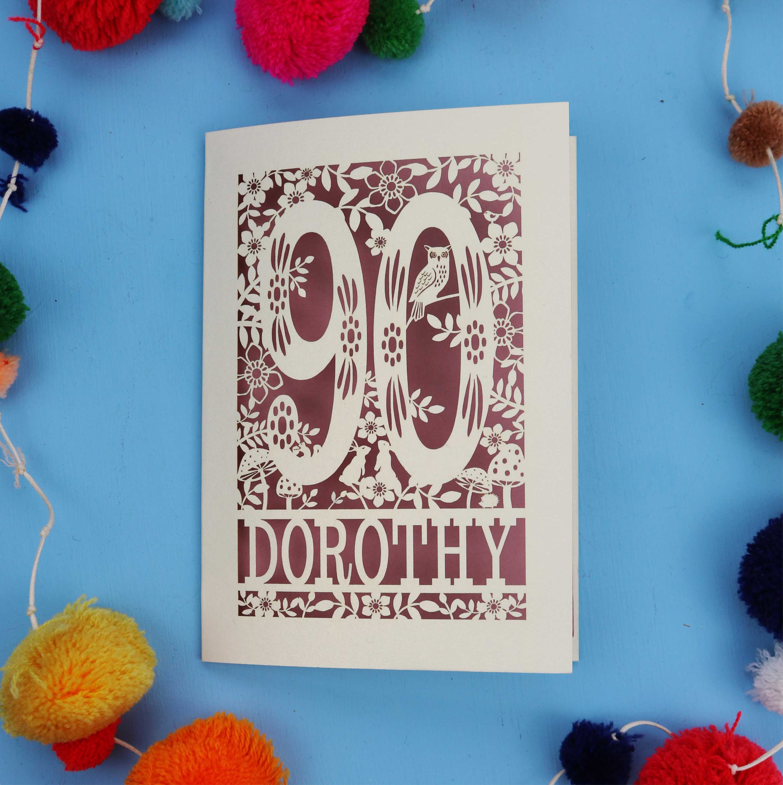 90th Birthday Card with '90 Dorothy' design on a blue background with colourful pom-poms.