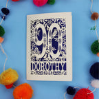 90th Birthday Card with '90 Dorothy' design on a blue background with colourful pom-poms.