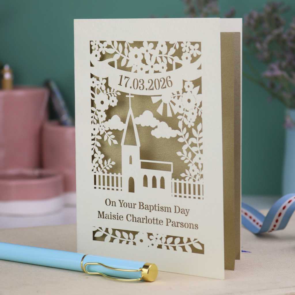 A laser cut Baptism card with floral cut out church design, a banner with cut out date in stencil font and text "On your Baptism Day, Maisie Charlotte Parsons"