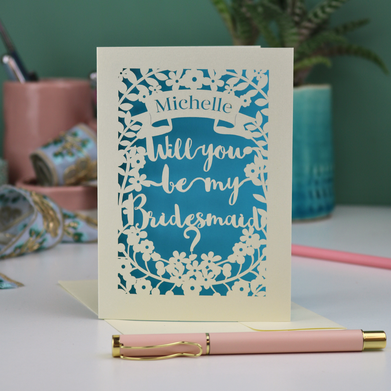 Laser cut Card with 'Will you be my Bridesmaid?' text on a desk with stationery items.