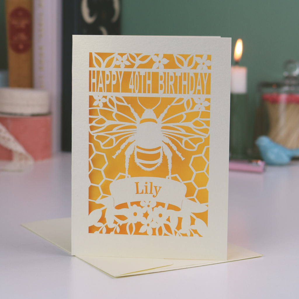 Birthday card with bee design and 'Happy 40th Birthday Lily' text on a blurred background
