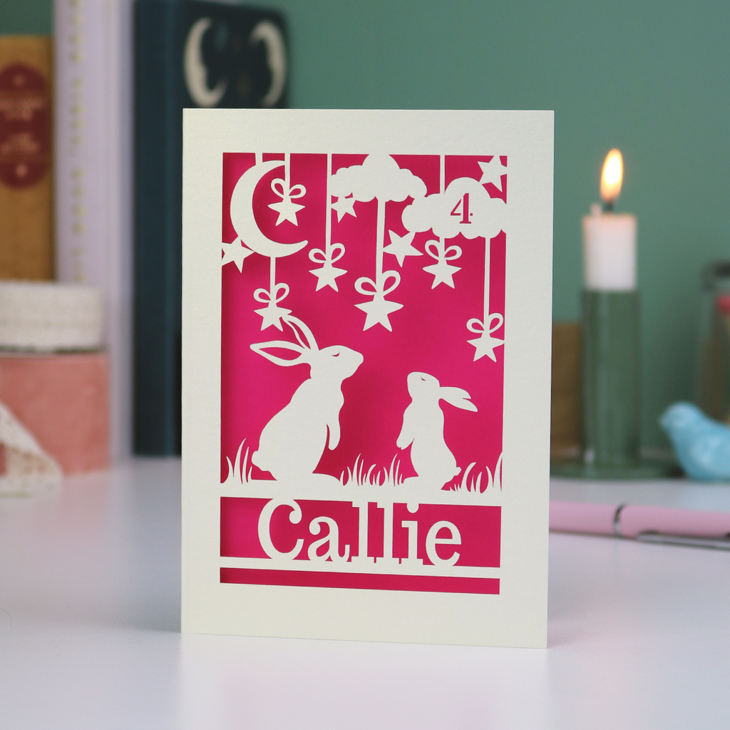 Birthday Card with cut-out designs of  bunny rabbits and decorative elements on a pink background, with 'Callie' written below.