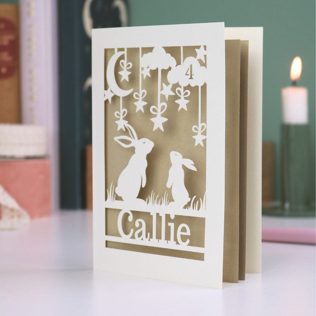 Bunny Birthday Card with cut-out designs of rabbits and text 'Callie' on a blurred background