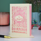 Decorative Cancer star sign birthday card with cancer zodiac design and 'Charis', 'Cancer' text on a table with a pen and candle.