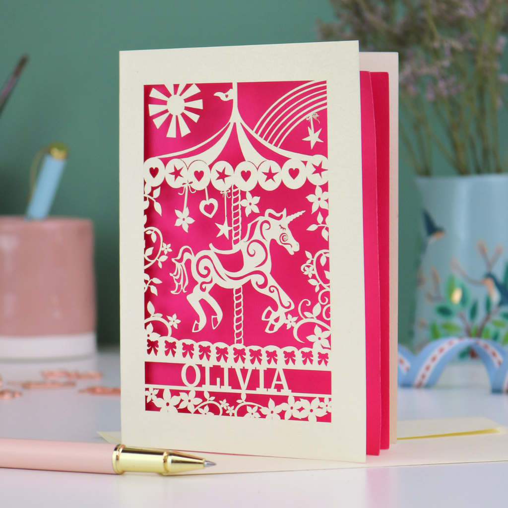 A laser cut girls birthday card with carousel design and personalised with a name. 
