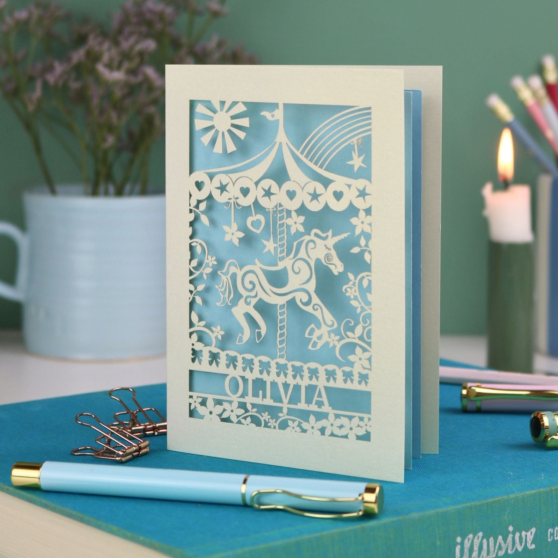 A laser cut carousel card with fairground horse design and personalised with the name Olivia at the bottom