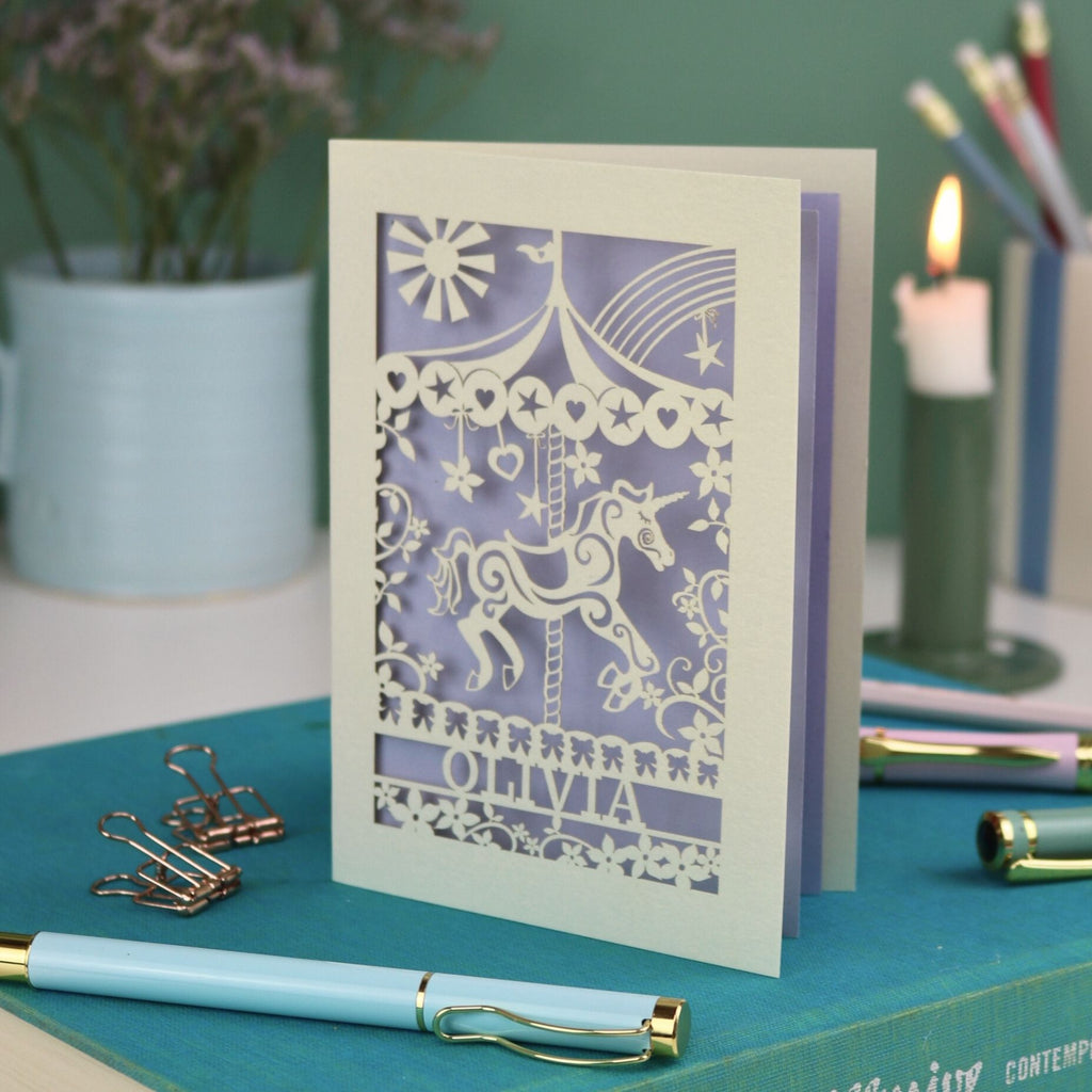 A laser cut carousel card with vintage fairground horse design and personalised with the name Olivia at the bottom