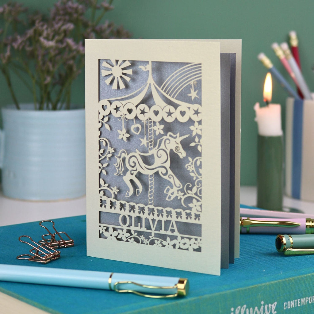 A laser cut carousel card with vintage fairground horse design and personalised with the name Olivia at the bottom