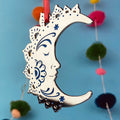A silver and blue crescent moon Christmas tree ornament