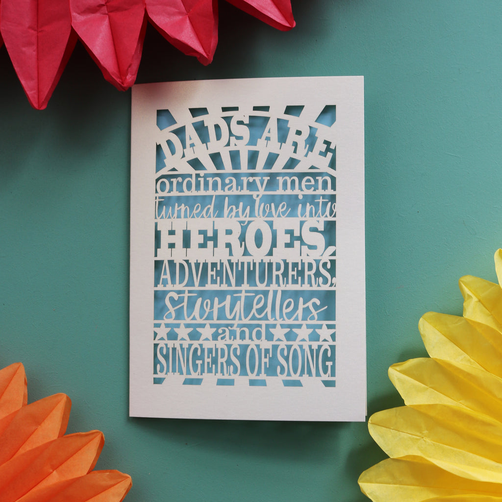 A beautiful father's day card laser cut with the words "dads are ordinary men turned by love into heroes, adventurers, storytellers and singers of song"