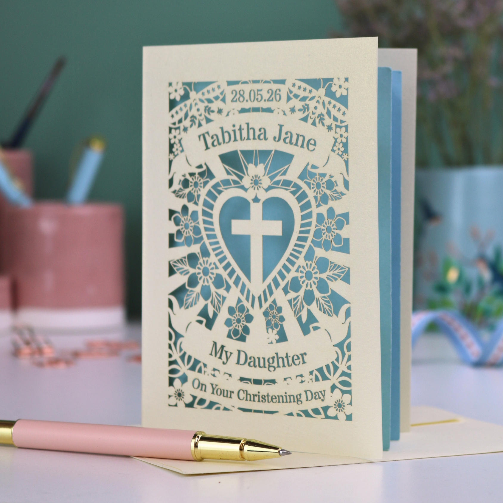 Personalised daughter christening card with decorative design and text on a table.