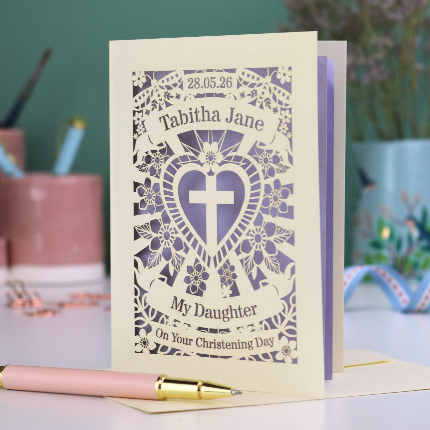Personalized laser cut daughter christening card with decorative elements on a table.