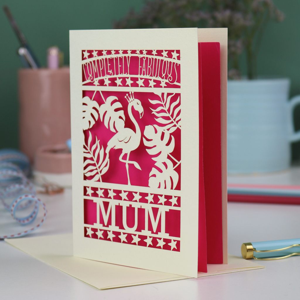 Greeting card with flamingo design and 'Completely Fabulous Mum' text on a desk with stationery items.