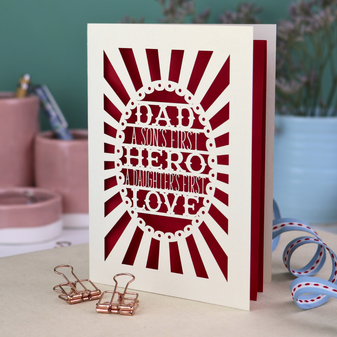 A laser cut sentimental Father's Day card with the cut out quote "Dad, a son's first hero, a daughter's first love"