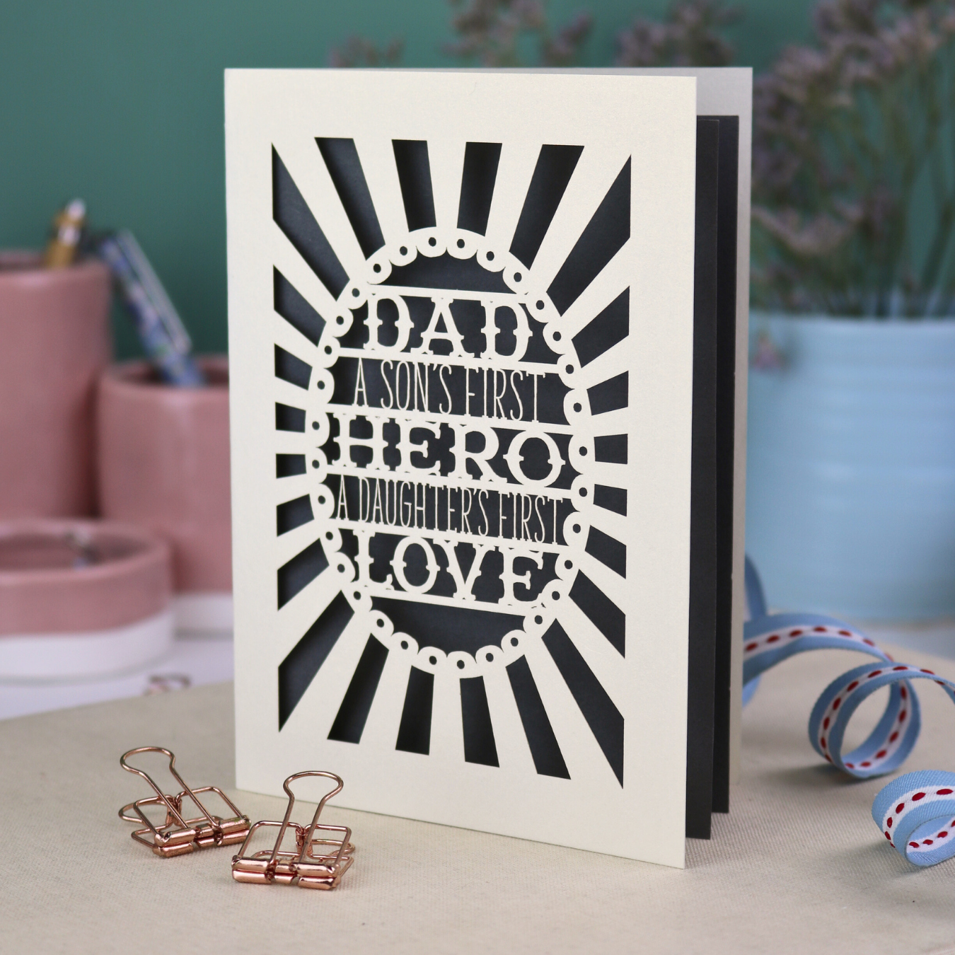 A laser cut sentimental Father's Day card with the cut out quote "Dad, a son's first hero, a daughter's first love"