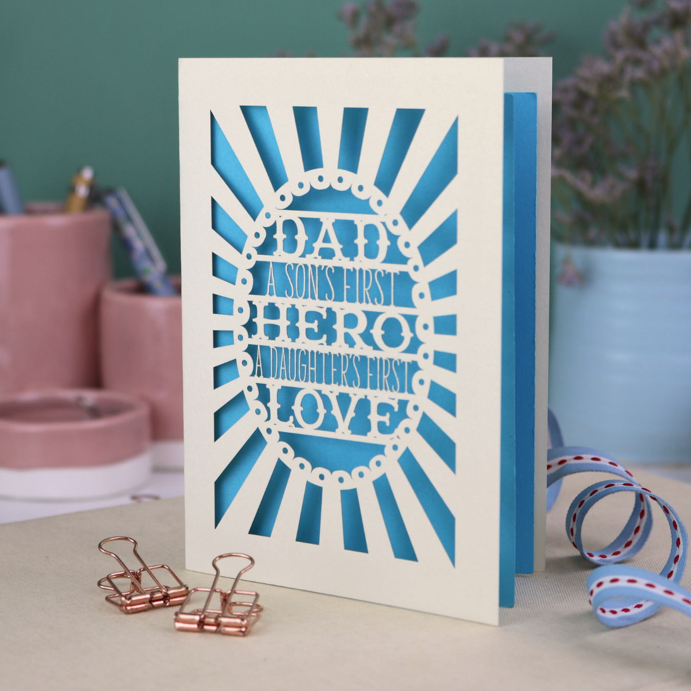 A laser cut sentimental Father's Day card with the cut out quote "Dad, a son's first hero, a daughter's first love"