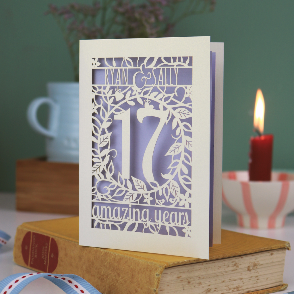Laser cut anniversary Card personalised with '17 amazing years' design on a book with a candle and cup in the background