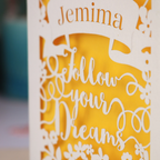 Decorative card with 'Jemima' and 'Follow your dreams' text on a yellow background