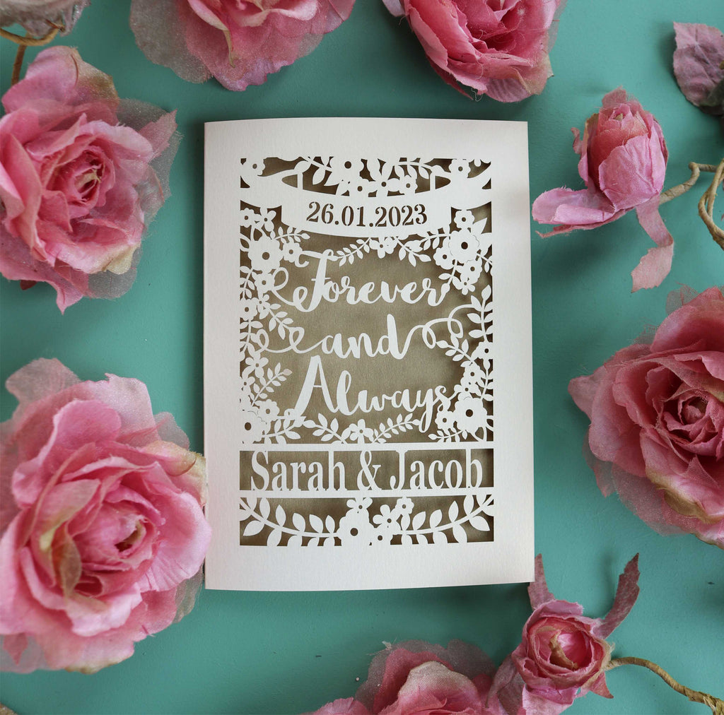 A laser cut engagement card that says Forever and Always, and is personalised with a date and the names of the couple.