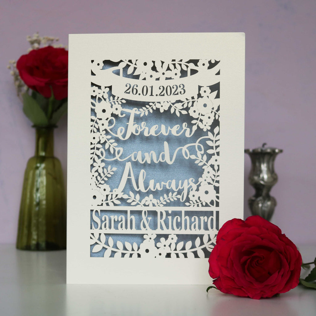 A papercut wedding card that says Forever and Always, and is personalised with a date and the names of the couple.