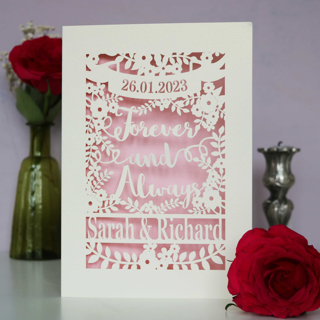 A papercut engagement card that says Forever and Always, and is personalised with a date and the names of the couple.